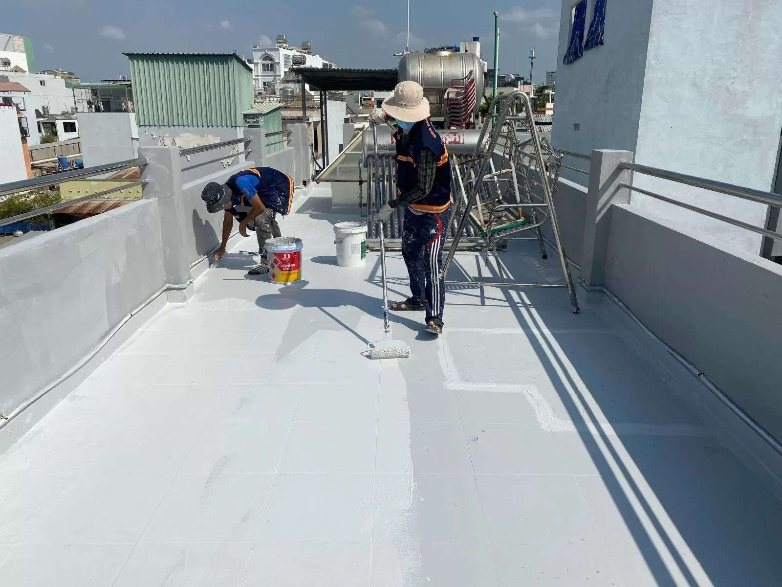 Hình ảnh nhân công đang thi công sơn lại bề mặt sân thượng tránh bị thấm nước